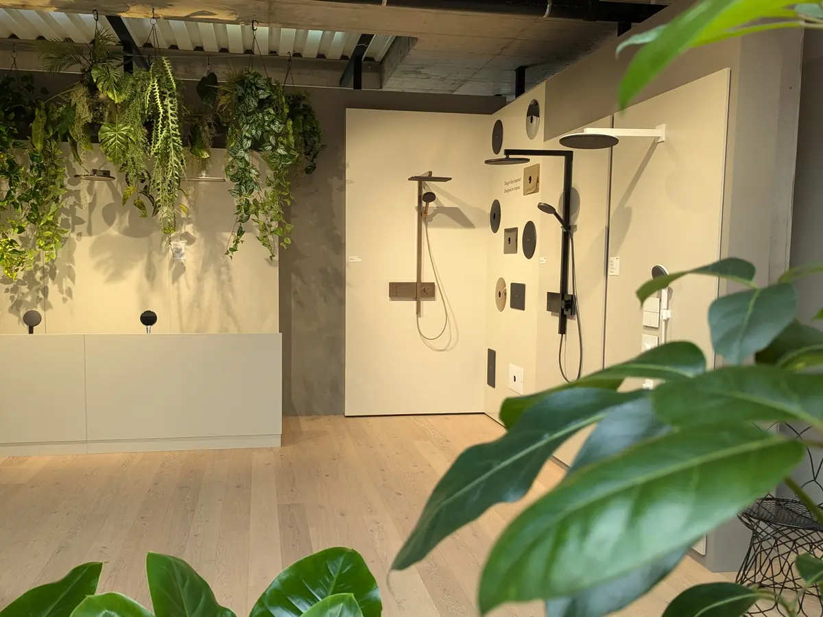 Hansgrohe-Ausstellung mit Duschsystemen, Kopfbrausen und Thermostaten, umrahmt von Grünpflanzen